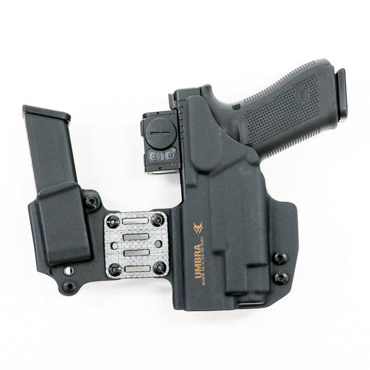 Rear view of the Umbra appendix holster system with an optic-equipped light-bearing pistol and spare magazine